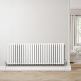 Sleek white oval single column radiator, 600 x 1620mm, with a modern design, mounted on a light wood floor against a neutral wall