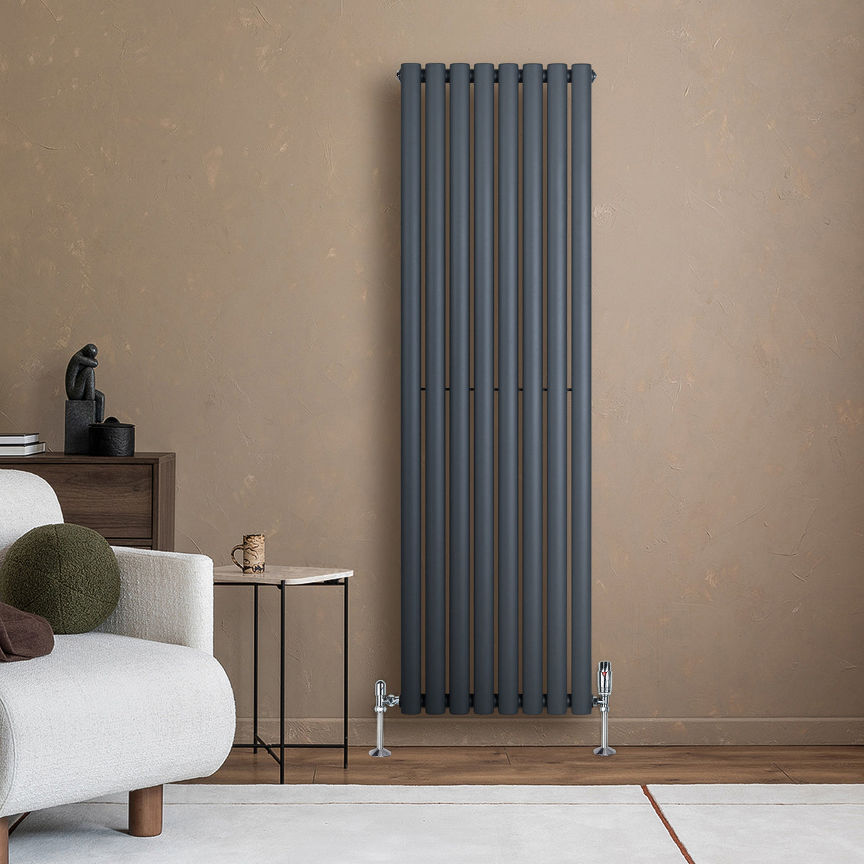 Sleek anthracite grey oval single column radiator, 1600 x 480mm, mounted on a textured beige wall, enhancing modern interior decor
