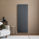 Sleek anthracite grey oval single column radiator mounted on a textured beige wall, complementing modern interior decor