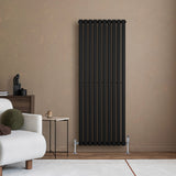 Sleek black oval single column radiator mounted on a textured beige wall, complementing modern furniture in a cozy living space