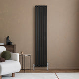 Sleek black oval single column radiator mounted on a textured beige wall, complementing modern interior decor with a minimalist design