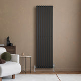 Sleek black oval single column radiator against a warm beige wall, complementing modern decor with a minimalist design