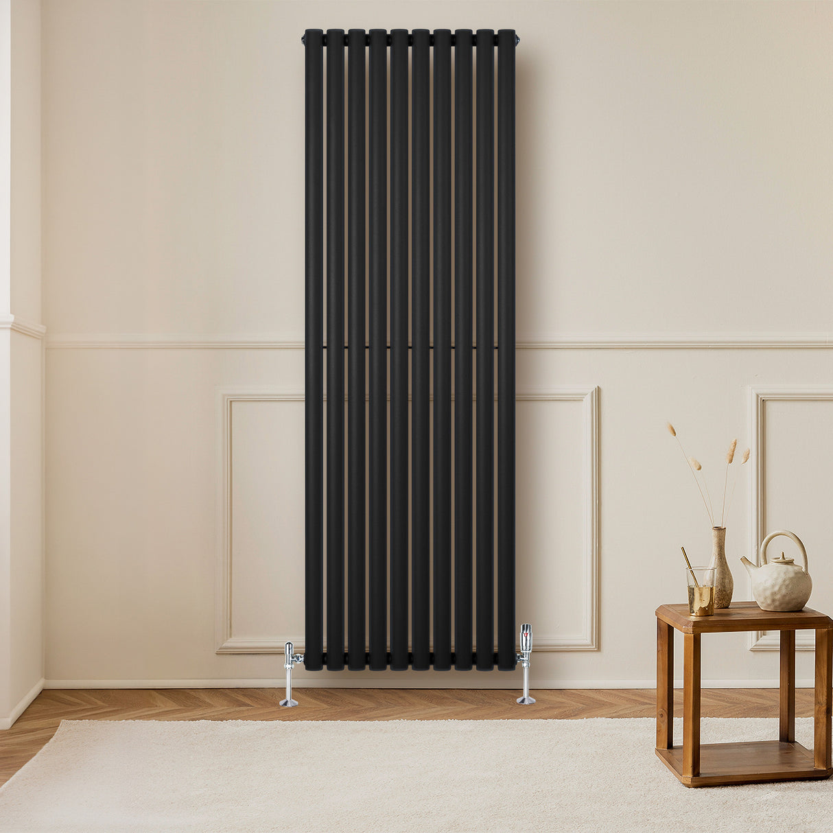 Sleek black oval single column radiator, 1800 x 600mm, mounted on a light wall, complementing a wooden table and decor elements