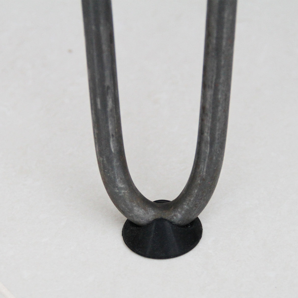 Black 10mm rubber feet protectors for hairpin legs, featuring a smooth texture and round shape, ideal for furniture stability