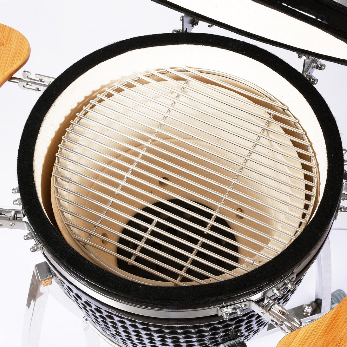 Kamado charcoal BBQ grill with a glossy black exterior, ceramic interior, and stainless steel cooking grate, showcasing its spacious design