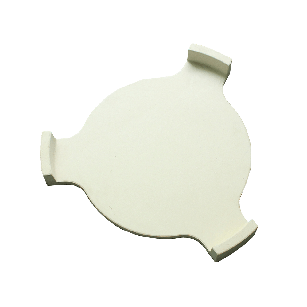 Round, white ceramic heat deflector for Kamado ovens, featuring smooth texture and curved edges for even heat distribution