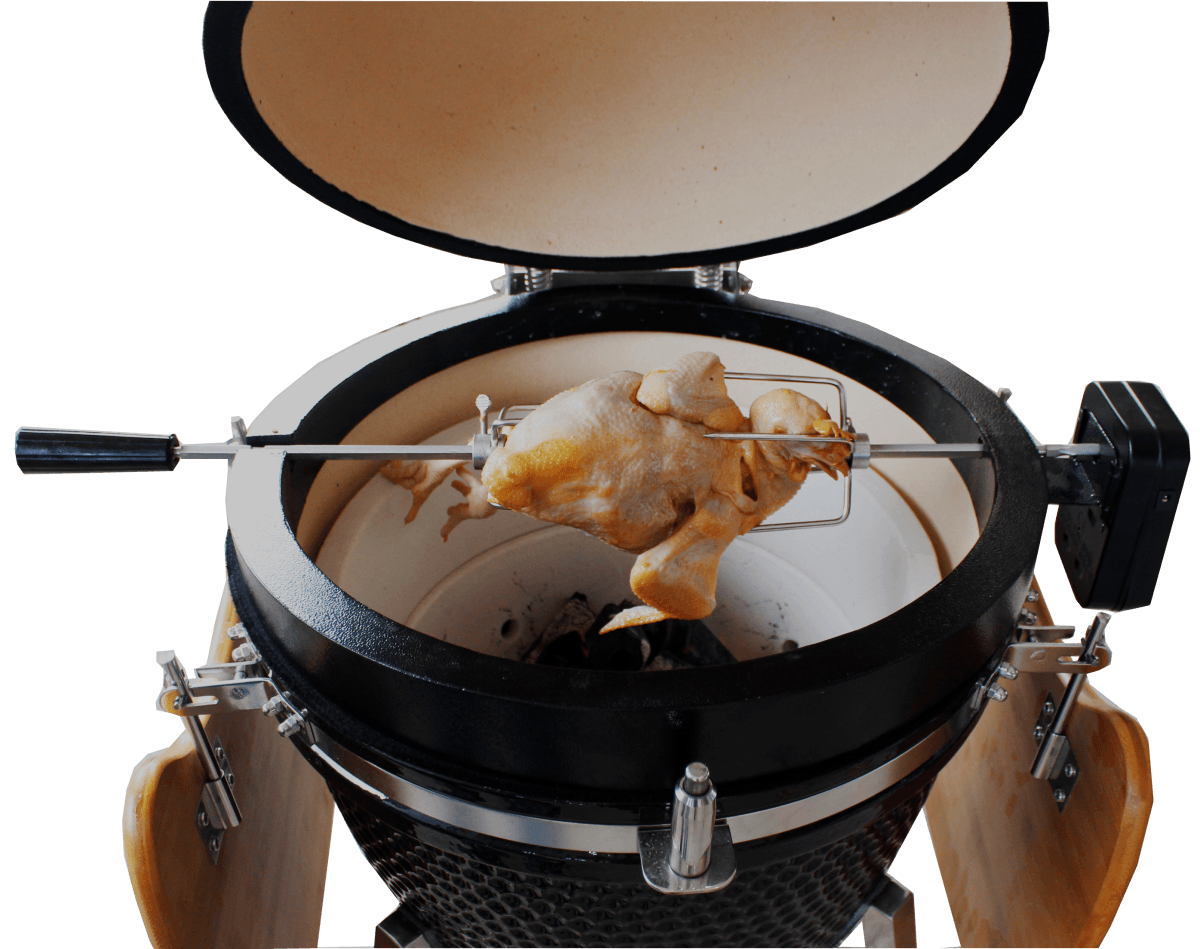 Kamado rotisserie grill with a golden-brown chicken on a spit, featuring a glossy black exterior and a ceramic interior