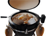 Kamado rotisserie grill with a golden-brown chicken on a spit, featuring a black exterior and a ceramic cooking chamber