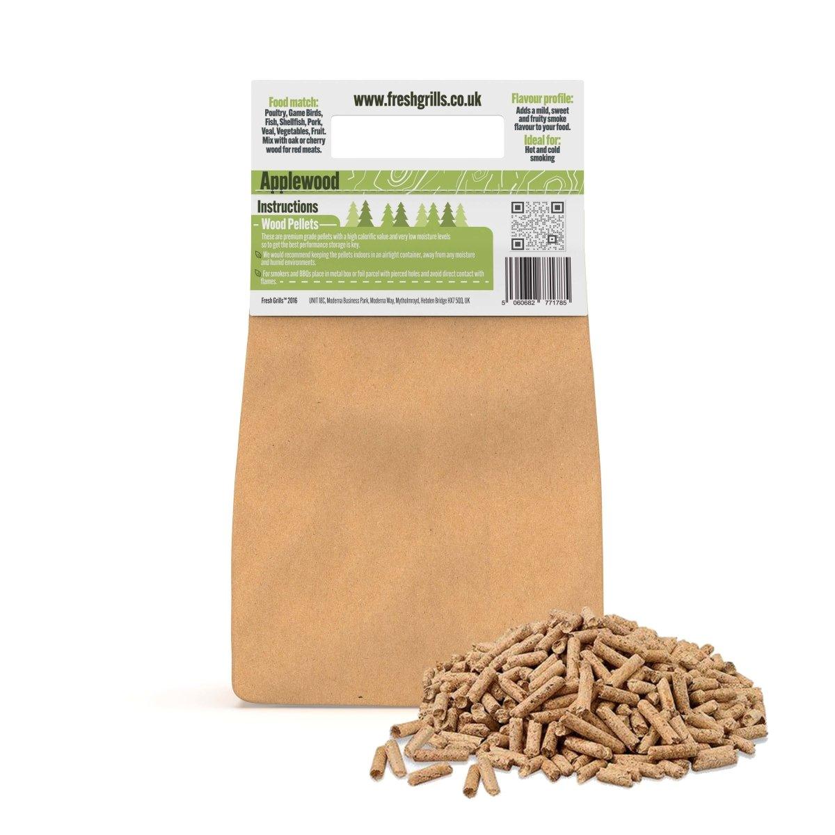 Applewood BBQ grill pellets in a brown paper bag, with a pile of pellets in front, ideal for enhancing flavor in outdoor cooking
