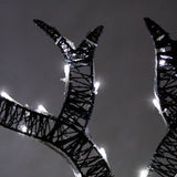 Glowing black metal reindeer antlers adorned with bright white lights, creating a festive and enchanting holiday display