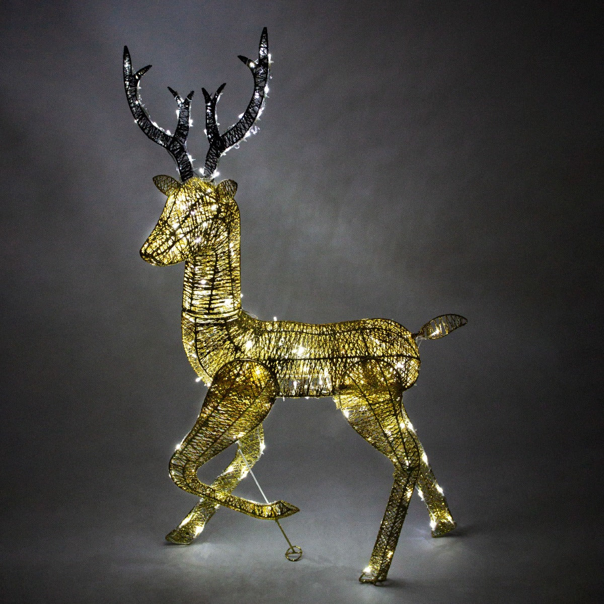 Gold stag reindeer with intricate wire design, illuminated with warm white lights, showcasing elegant antlers and a graceful stance