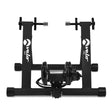 Variable resistance magnetic indoor bike trainer with a sturdy black frame, adjustable clamps, and a compact design for road and mountain bikes